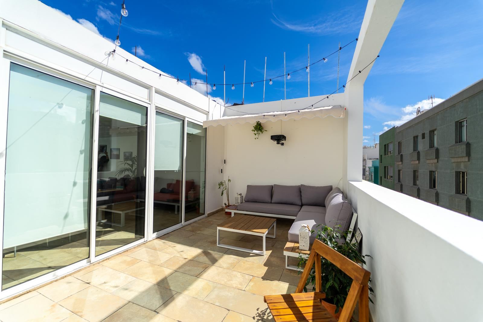 Terrace corner with outdoor shower and bar stools