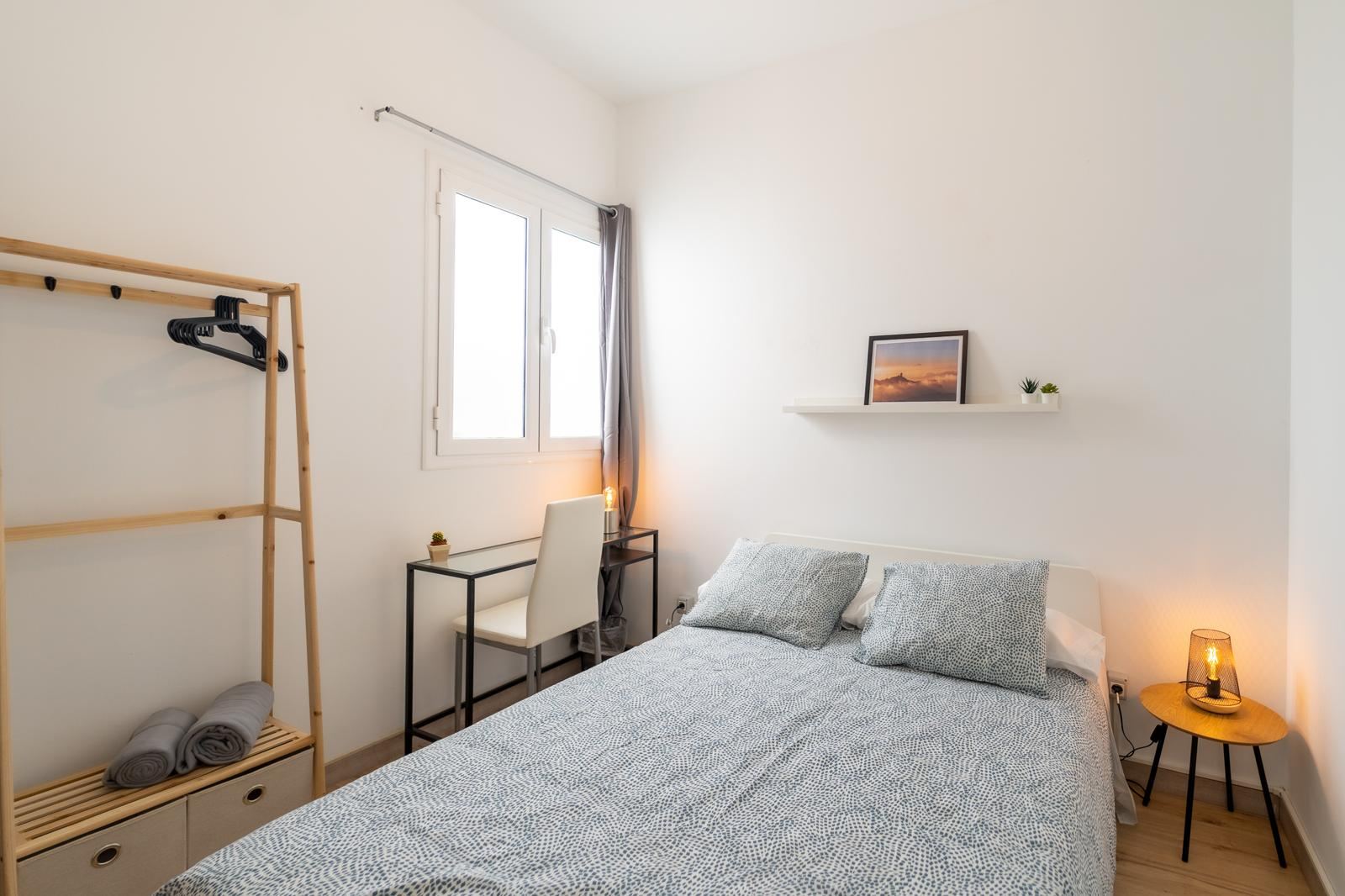 Bedroom with double bed and framed print on shelf