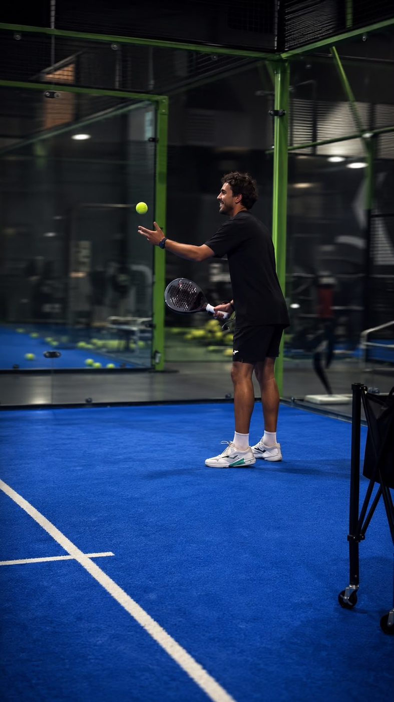 La Pala coach serving on an indoor padel court